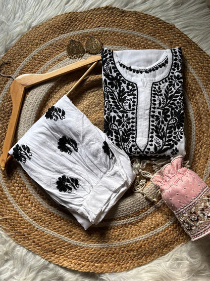 Folded white rayon Lucknow Chikankari kurta and shalwar set with black embroidery