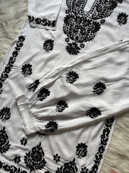 Close up of black Lucknow Chikankari embroidery on white rayon shalwar set