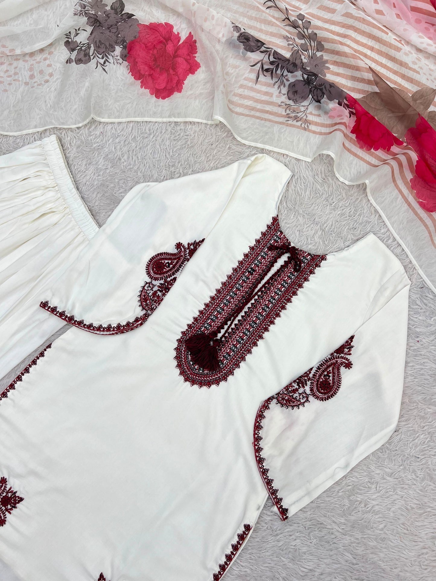 Close view of white kurta with maroon embroidery and floral dupatta