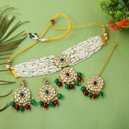 Multi color imitation jewellery necklace set with earrings and maang tikka flat lay