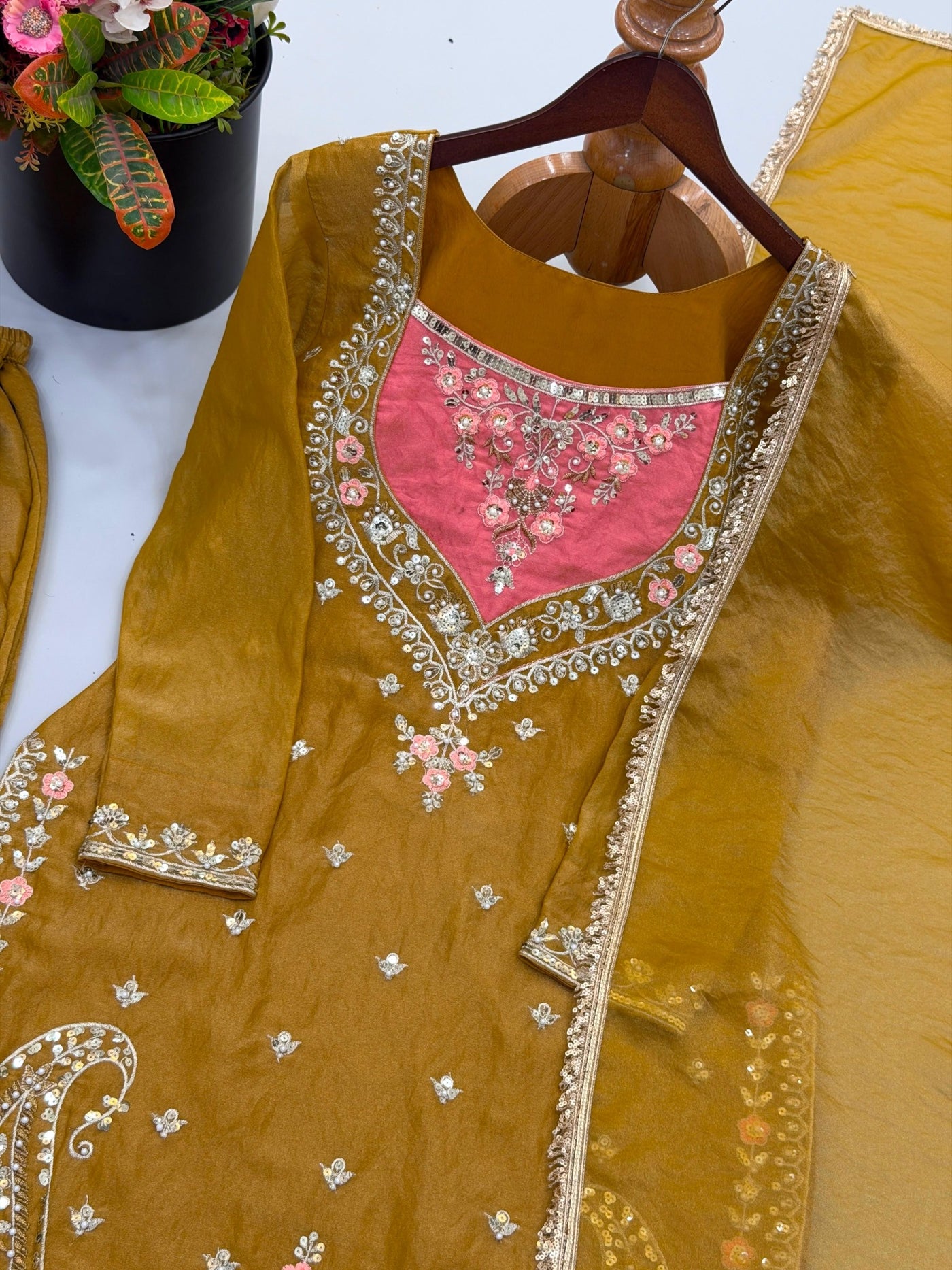 Antique gold top with peach neckline and sequin embroidery close-up