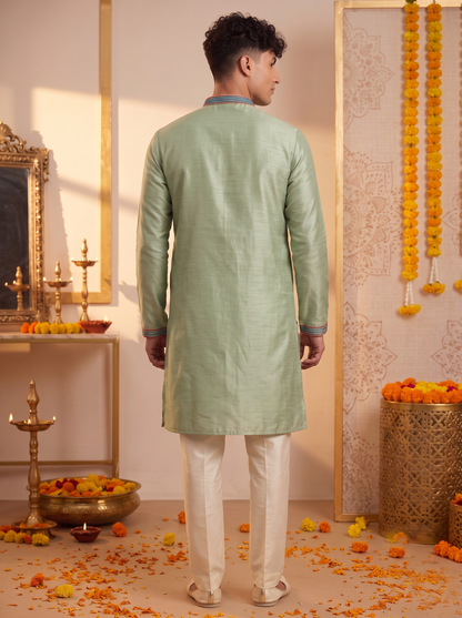 Men's sage green silk kurta and ivory trouser set back view