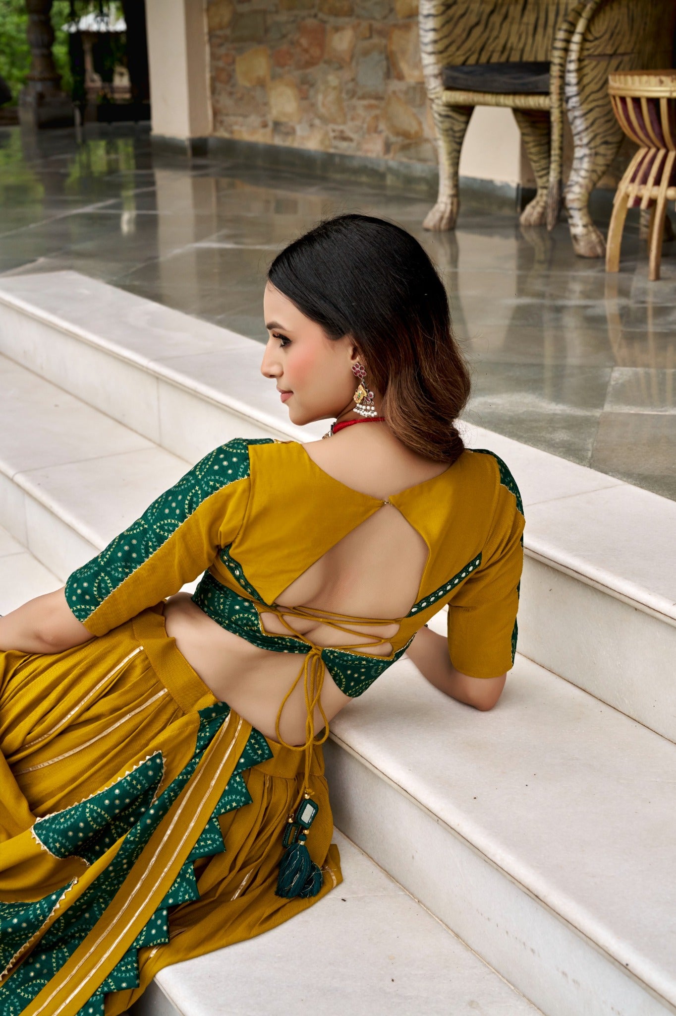 Mustard yellow Navratri blouse back design with bottle green Ajrakh accents and tassels