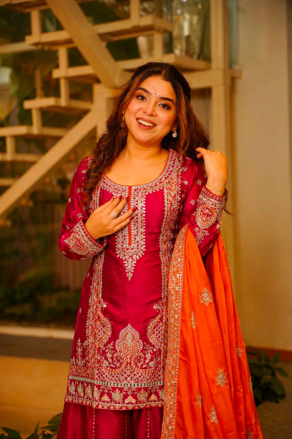 Model wearing Rani pink embroidered Chinon silk kurti with orange dupatta